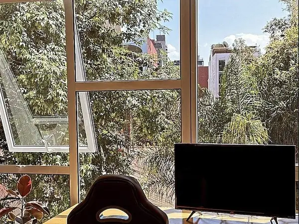 Work corner with floor-to-ceiling windows onto mature trees
