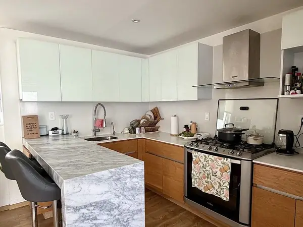 Kitchen with marble island and white cabinetry