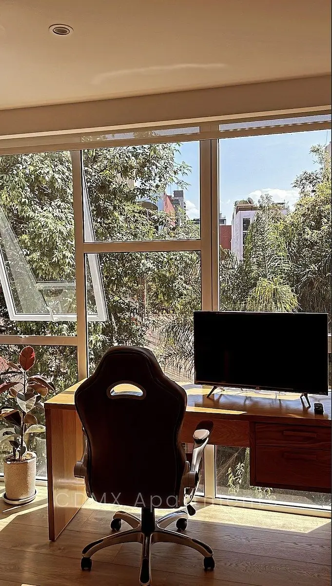 Bedroom with a wall of windows facing the trees
