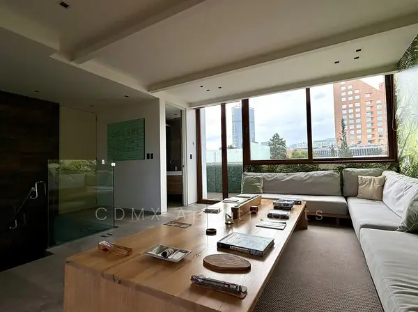 Living room with a wall of windows and city views