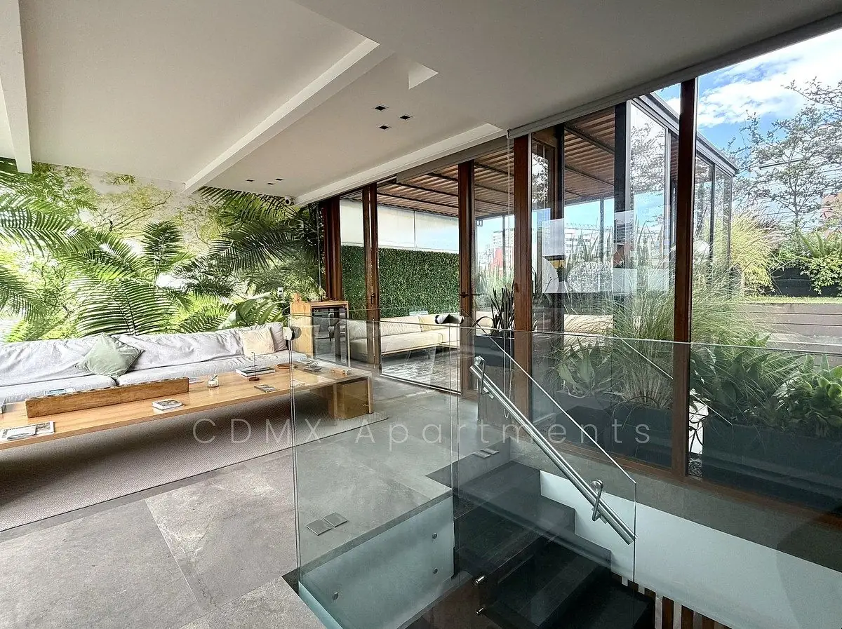 Glass staircase landing with living area and plants