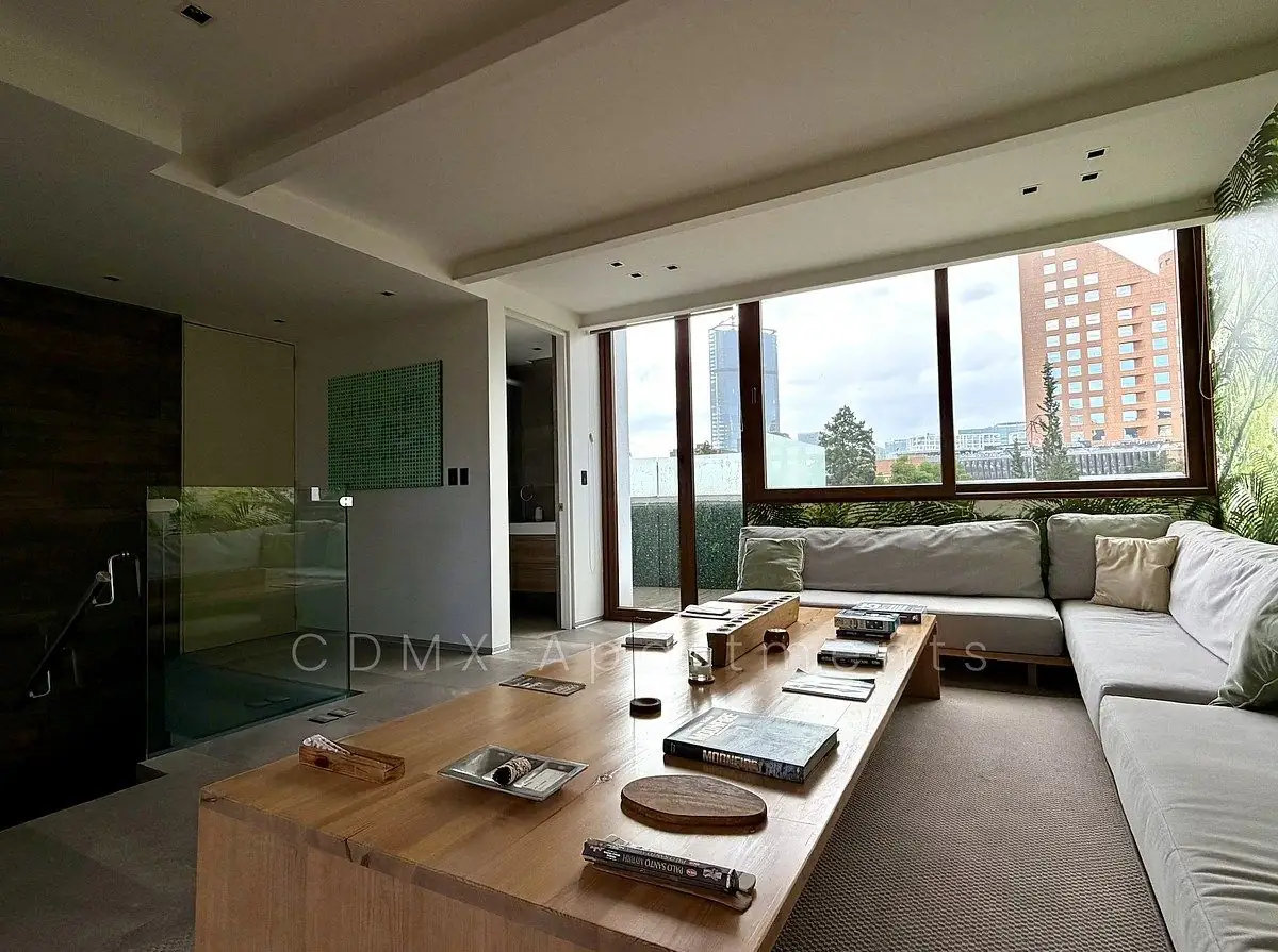 Living room with a wall of windows and city views